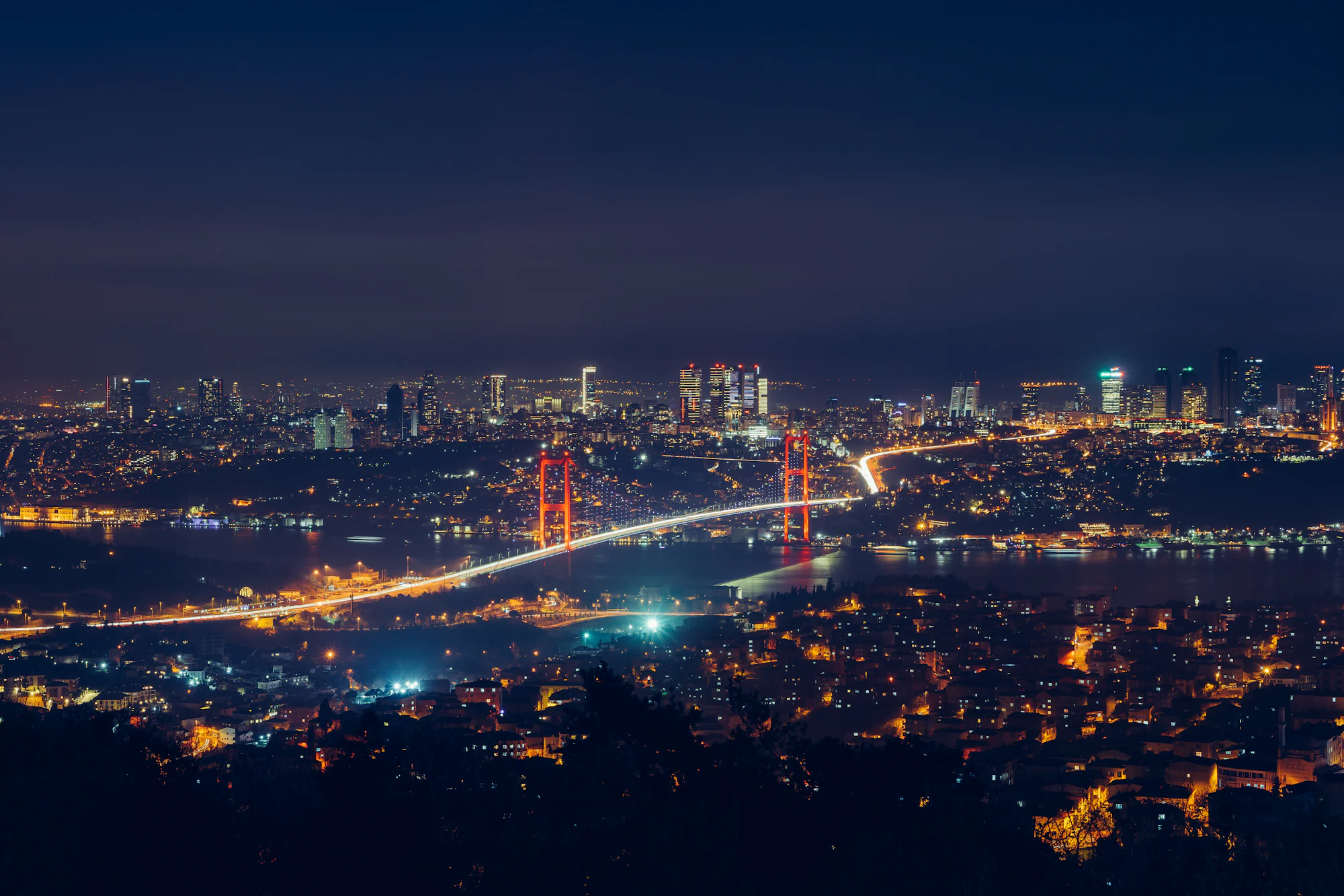 Gece yukarıdan İstanbul: Boğaz Köprüsü iki yakayı birleştiriyor, arkada Levent'in ışıkları